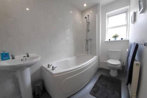 Stylish 2 bed 2 bathroom apartment for up to 5 في وارويك: حمام أبيض مع حوض ومرحاض ومغسلة