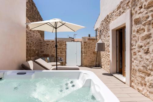 a bath tub in a patio with an umbrella at Forum Boutique Hotel & Spa - Adults Only in Alcudia