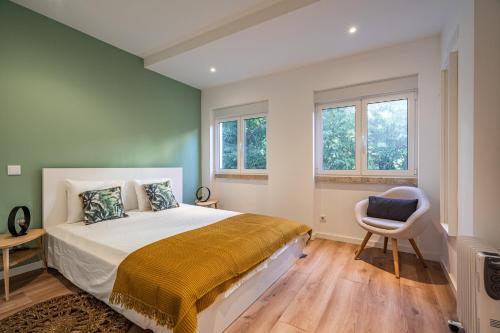 Schlafzimmer mit einem Bett, einem Stuhl und Fenstern in der Unterkunft Akicity Anjos Moss in Lissabon
