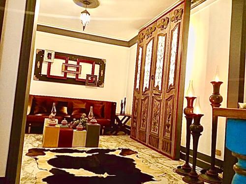 Luxury apartment Alexandria في الإسكندرية: غرفة معيشة مع باب خشبي كبير وطاولة
