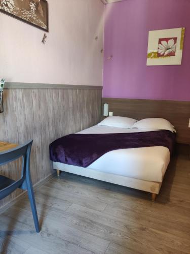 a bedroom with a bed with a purple wall at Atipik Hôtel in Annecy