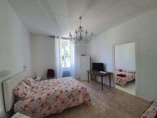 une chambre blanche avec un lit et un miroir dans l'établissement Maison Laurenza/ La Liversoise, à Saint-Jean-de-Liversay