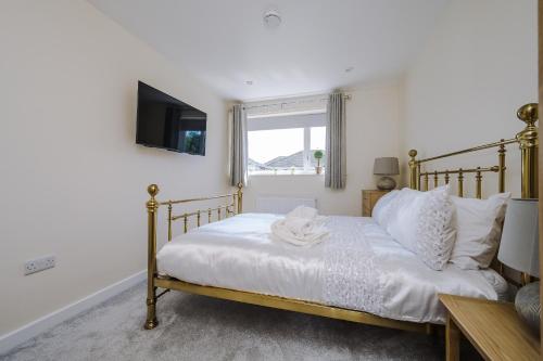 ein Schlafzimmer mit einem Bett und einem TV an der Wand in der Unterkunft Buttercup Bungalow in Blackpool in Blackpool