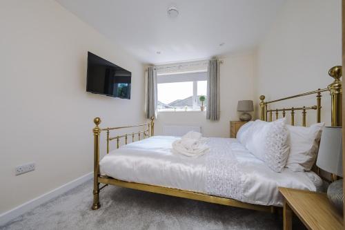 a bedroom with a bed and a tv on the wall at Buttercup Bungalow in Blackpool in Blackpool