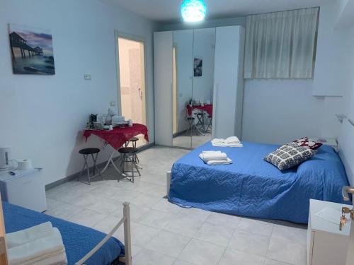 a bedroom with a blue bed and a table at Casa di Ale in Diamante