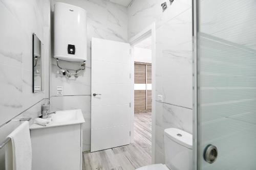 biała łazienka z prysznicem i toaletą w obiekcie Apartamento Venus 1 w mieście Conil de la Frontera