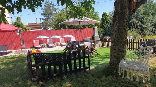 a table and chairs under an umbrella next to a tree at Casa Lyna in Gyomaendrőd