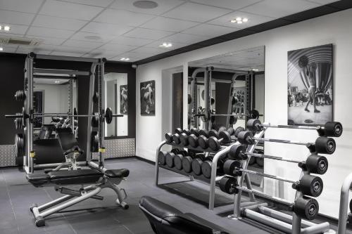 a gym with two rows of weight machines and mirrors at Fairlawns, Hotel And Spa in Walsall