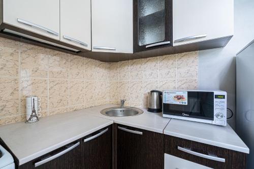 a small kitchen with a sink and a microwave at Аpartment near Central Vokzal in Minsk