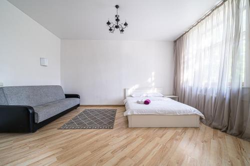 a bedroom with a bed and a couch at Аpartment near Central Vokzal in Minsk