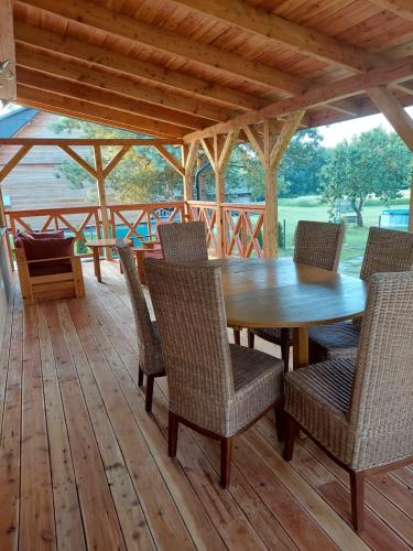 a wooden table and chairs on a wooden deck at Niemirowska Osada in Niemirów