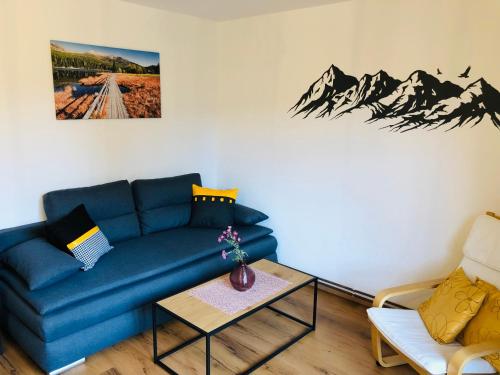a living room with a blue couch and a table at Pernerhof in Mariapfarr