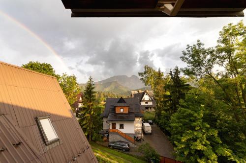a rainbow in the sky over a town with a house at Apartment Wojciecha Brzegi Zakopane by Renters in Zakopane