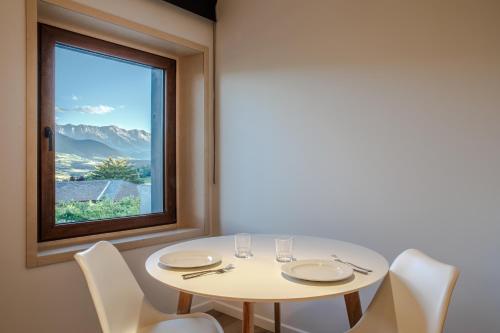 a white table with chairs and a window at Cerdanya Viva Ecoestades in Prullans