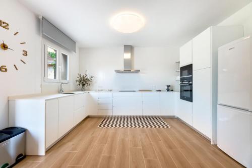 a kitchen with white cabinets and a clock on the wall at Es Cos in Algaida
