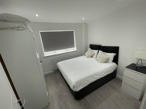 a small bedroom with a bed and a window at London Dagenham Apartments in Dagenham