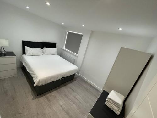 a small bedroom with a bed and a window at London Dagenham Apartments in Dagenham
