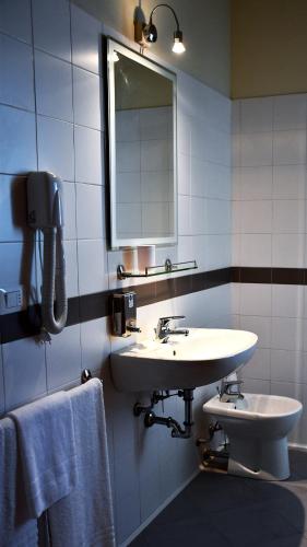 a bathroom with a sink and a mirror at Eco Rooms & Apartments in Voghera