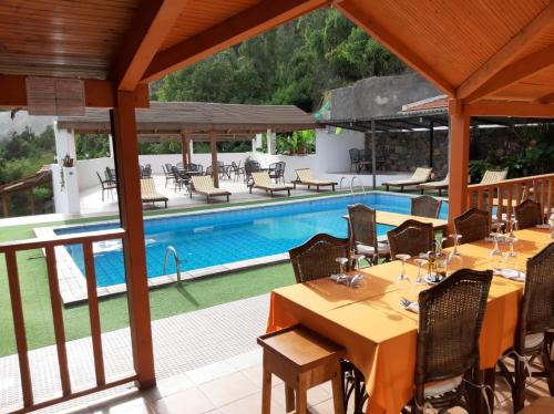 a resort with a pool and tables and chairs at Pedracin Village in Ribeira Grande