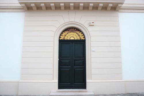 a black door on a white building with a window at B&B Il Giardino di Paola in Alliste