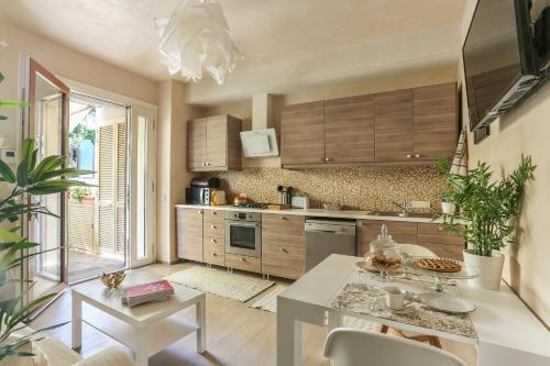 a kitchen with wooden cabinets and a white table and chairs at Il Capriolino in Tavarnuzze
