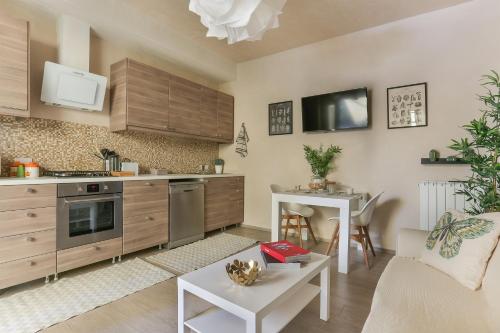 a kitchen with wooden cabinets and a living room at Il Capriolino in Tavarnuzze