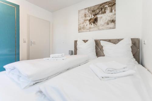 1 dormitorio blanco con 2 camas y almohadas blancas en Smart Resorts Haus Rubin Ferienwohnung 101, en Winterberg