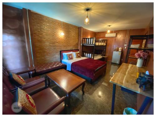 a room with a bed and a couch and a table at The One House in Nan