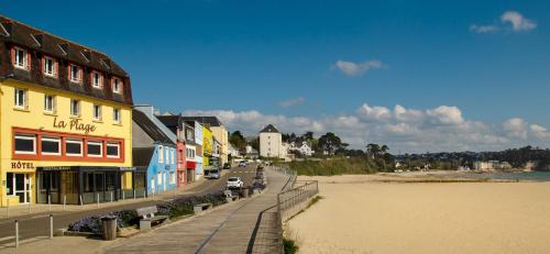 a street next to a beach with a building at Hôtel & Restaurant de la Plage in Crozon