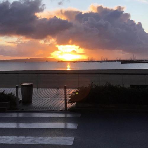 a sunset over the ocean with the sun setting at Hôtel & Restaurant de la Plage in Crozon