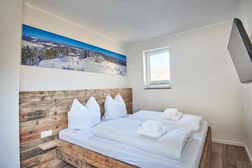 um quarto com uma cama com almofadas brancas em Smart Resorts Haus Opal Ferienwohnung 402 em Winterberg