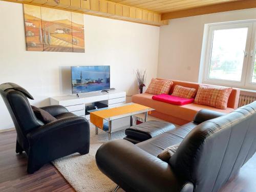 a living room with a couch and a tv at FeWo Royal & Goodness Home in Mühlhausen