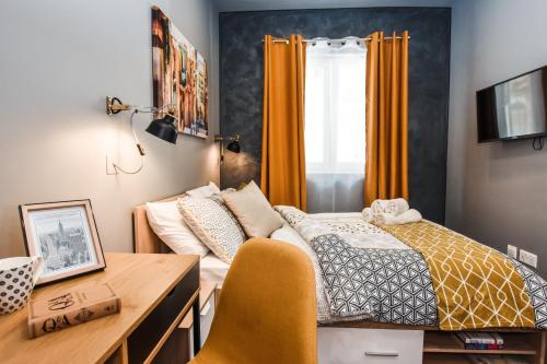 a small bedroom with a bed and a desk at Cosy Albert's Seaside Suites (Sliema) in Sliema