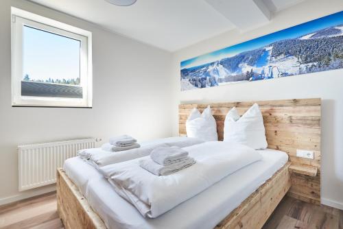 a bedroom with a large bed with white sheets at Smart Resorts Haus Saphir Ferienwohnung 507 in Winterberg