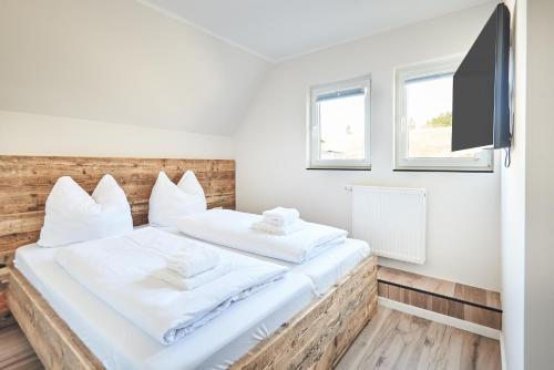 - une chambre avec un lit et une télévision murale dans l'établissement Smart Resorts Haus Opal Ferienwohnung 406, à Winterberg