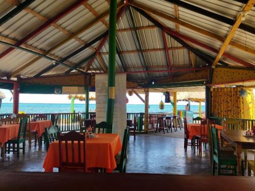 a restaurant with tables and chairs and the ocean at Cool Spot Grace Place in Little Corn Island
