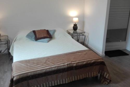 ein Schlafzimmer mit einem Bett mit zwei Tischen und einer Lampe in der Unterkunft L'appART'en ciel. Climatisé entre mer et canal in Villeneuve-lès-Béziers