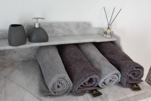 eine Reihe von Handtüchern auf einem Regal in einem Badezimmer in der Unterkunft L'appART'en ciel. Climatisé entre mer et canal in Villeneuve-lès-Béziers