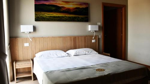 ヴォゲーラにあるEco Rooms & Apartmentsのベッド1台(壁にランプ2つ付)