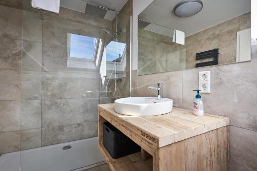 a bathroom with a sink and a mirror and a tub at Smart Resorts Haus Saphir Ferienwohnung 511 in Winterberg