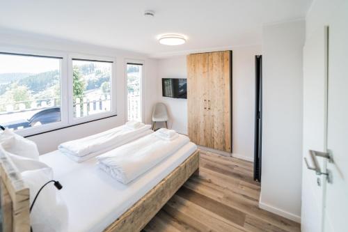 ein weißes Schlafzimmer mit einem Bett und einem Fenster in der Unterkunft Smart Resorts Haus Diamant Ferienwohnung 712 in Winterberg