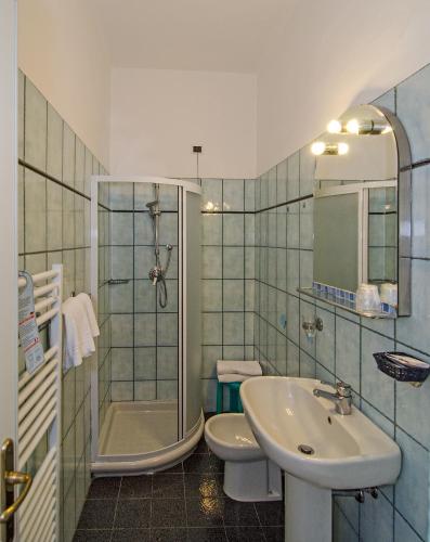 a bathroom with a sink and a shower and a toilet at Hotel Villa Flores in Marina di Pietrasanta