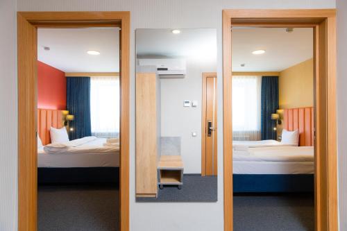 a view of a room with two beds and a mirror at Отель KOKSHETAU in Kokshetau