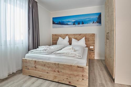 a bedroom with a wooden bed with white sheets and pillows at Smart Resorts Haus Azur Ferienwohnung 808 in Winterberg