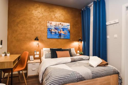 1 dormitorio con 1 cama y escritorio con escritorio en Cosy Albert's Seaside Suites (Sliema) en Sliema