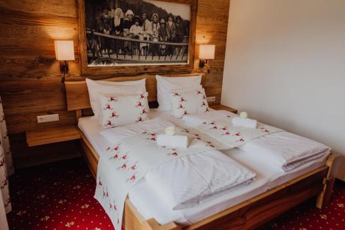 a bedroom with two beds with white sheets at Panorama Hotel Gasthof Leidingerhof in Mondsee