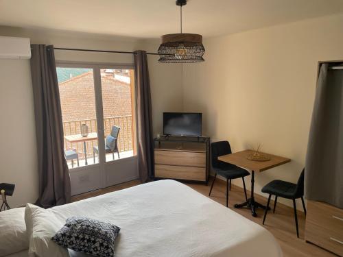 een slaapkamer met een bed, een tafel en een televisie bij Les résidences du port appartements meublés in Porto Ota