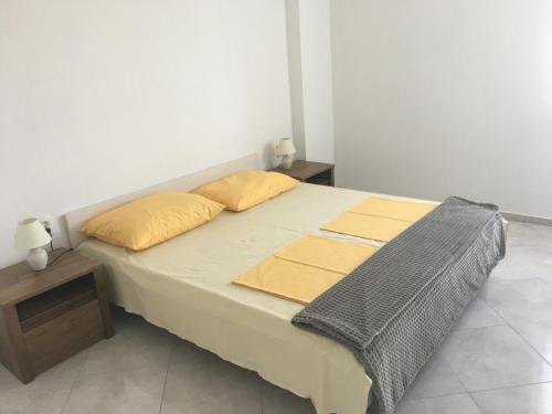a bed with two pillows on it in a room at Apartments MiaMaja in Novalja