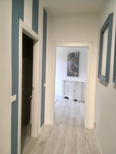 an empty room with a hallway with blue and white walls at Acqua Chiara Apartment by Rent All Como in Dongo