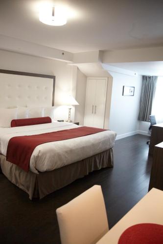 a hotel room with two beds and a table and chairs at Admiral Inn Mississauga in Mississauga